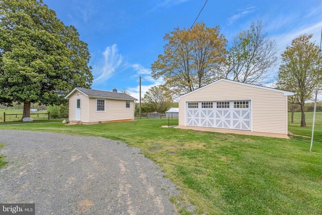 view of yard featuring a garage, an outdoor structure, and fence