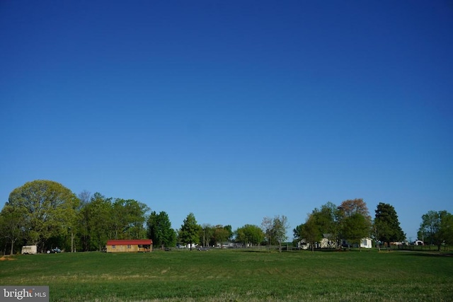 exterior space featuring a lawn and a rural view