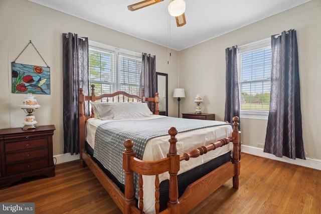 bedroom featuring multiple windows, a ceiling fan, and wood finished floors