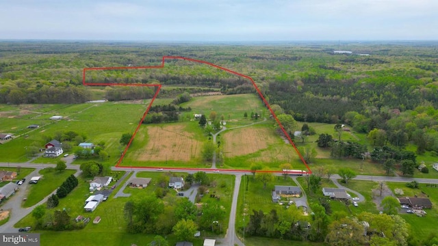 birds eye view of property featuring a view of trees and a rural view