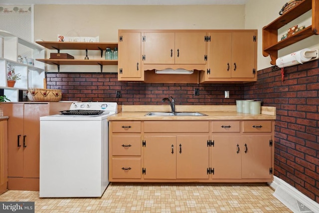 kitchen with visible vents, washer / dryer, open shelves, a sink, and light countertops