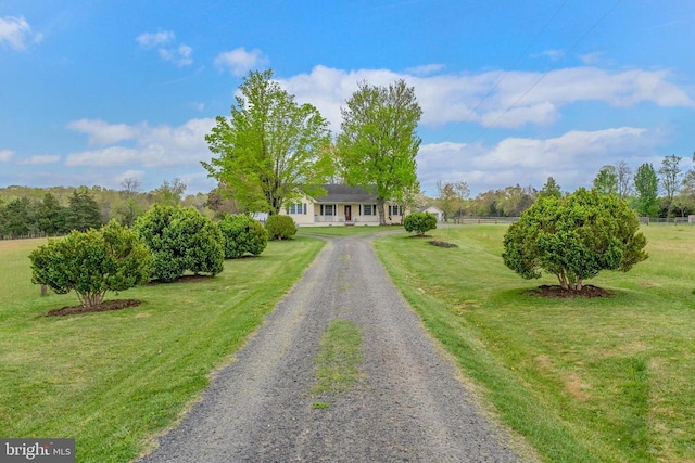 ranch-style home with driveway, a front lawn, and fence