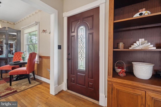 foyer with wainscoting and light wood-style flooring