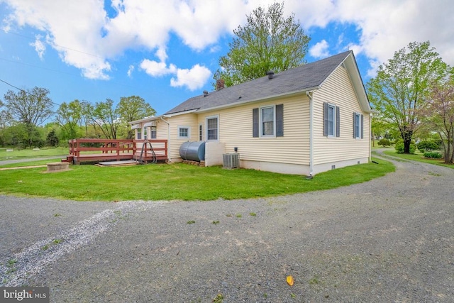 exterior space with driveway, heating fuel, a yard, a wooden deck, and central AC unit