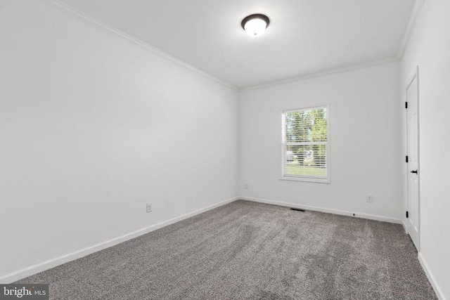 carpeted empty room with baseboards, visible vents, and crown molding