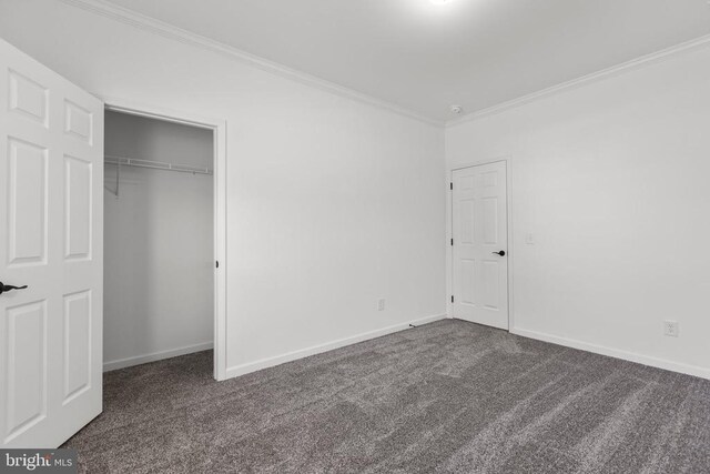 unfurnished bedroom featuring baseboards, a closet, carpet, and crown molding