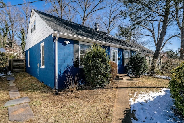 view of front of house featuring concrete block siding and roof with shingles