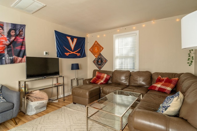 living area with visible vents and wood finished floors