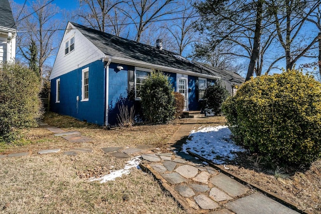 view of front of property with entry steps, a shingled roof, and concrete block siding