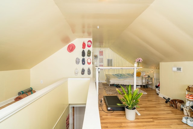 additional living space with vaulted ceiling and wood finished floors