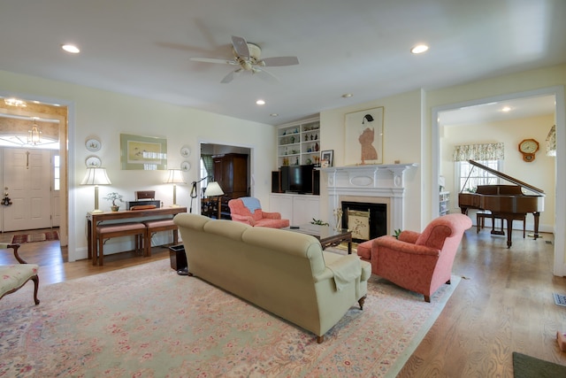 living area featuring a ceiling fan, wood finished floors, recessed lighting, and a fireplace