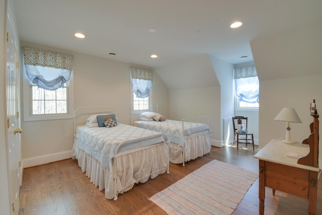 bedroom with recessed lighting, wood finished floors, baseboards, and multiple windows