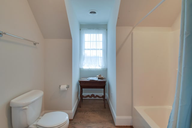 bathroom featuring vaulted ceiling, wood finished floors, baseboards, toilet, and visible vents