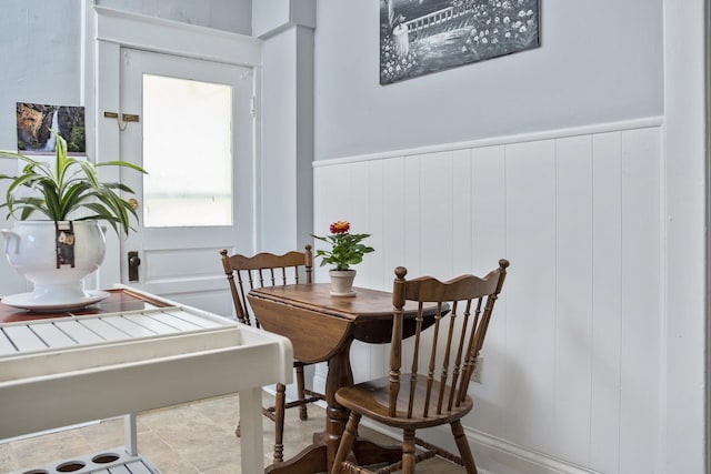 dining room featuring a decorative wall and wainscoting