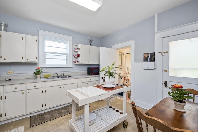 kitchen featuring a sink, light countertops, and white cabinetry