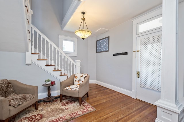 foyer featuring baseboards, stairs, and wood finished floors