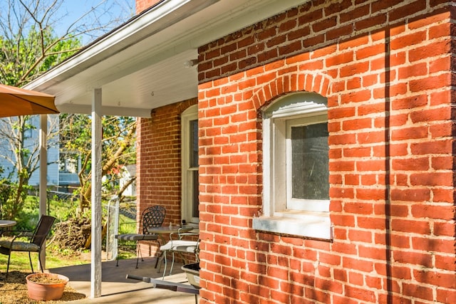 view of side of property featuring brick siding and fence
