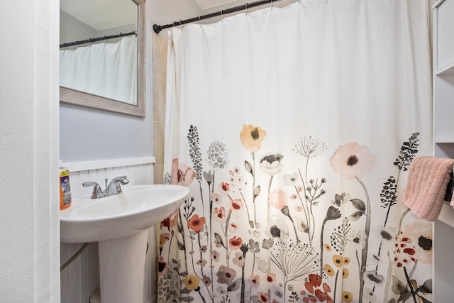 bathroom with a sink and tasteful backsplash