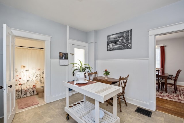 dining area featuring a wainscoted wall and visible vents