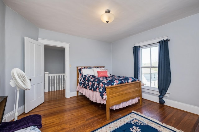 bedroom with baseboards and wood finished floors