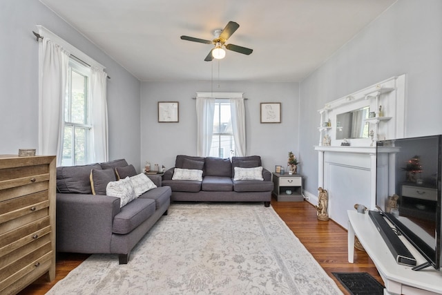 living area with a ceiling fan and wood finished floors