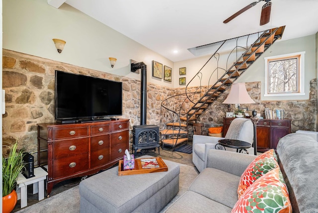 living room with a wood stove, light colored carpet, and ceiling fan