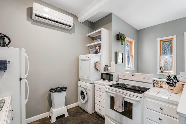 kitchen with white appliances, a wall unit AC, stacked washer and dryer, white cabinets, and tile counters