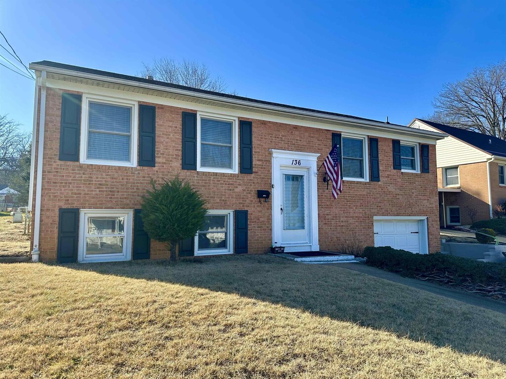 split foyer home with a garage and a front yard