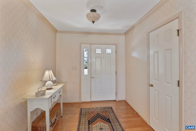 entryway with wallpapered walls, baseboards, ornamental molding, and wood finished floors