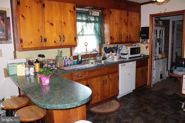 kitchen featuring sink, a breakfast bar area, kitchen peninsula, white appliances, and decorative backsplash