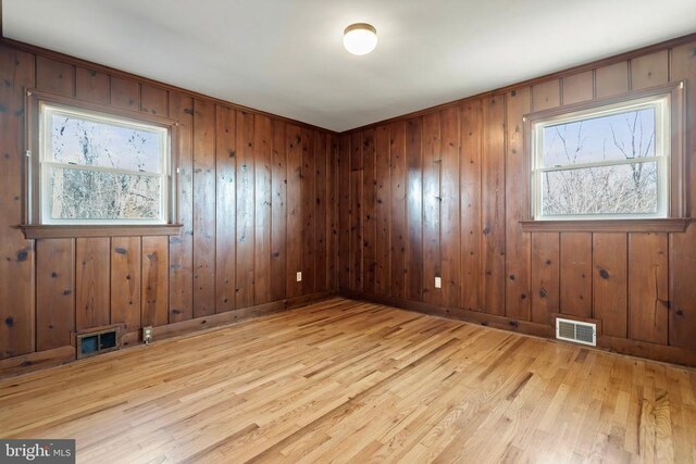 unfurnished room featuring visible vents, baseboards, and light wood-style floors