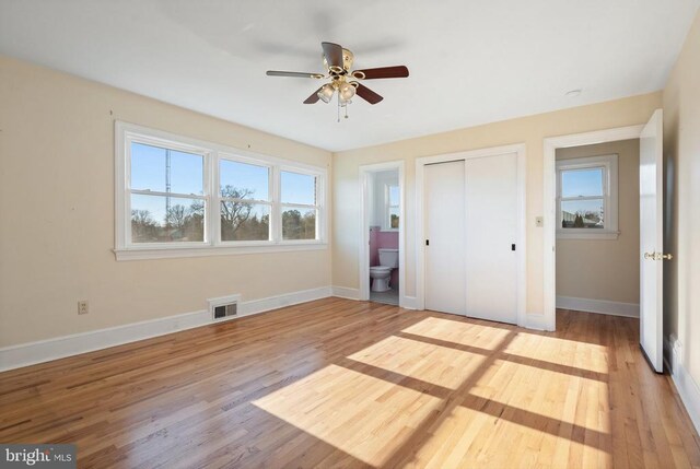 unfurnished bedroom with a closet, visible vents, light wood-style flooring, and baseboards