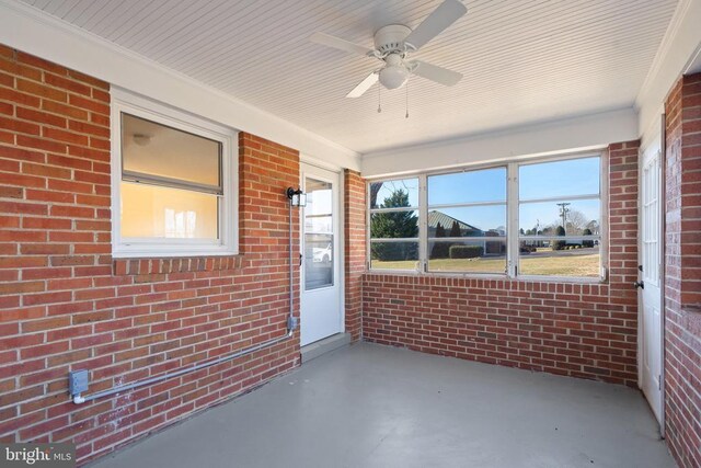 unfurnished sunroom with ceiling fan