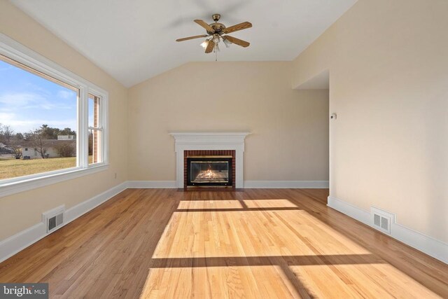 unfurnished living room featuring lofted ceiling, wood finished floors, visible vents, and baseboards