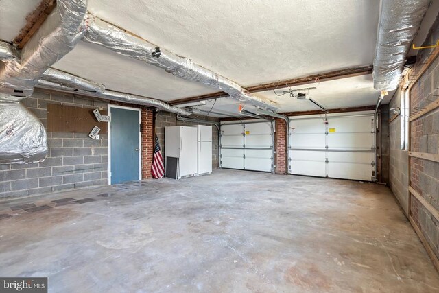 garage with concrete block wall and a garage door opener