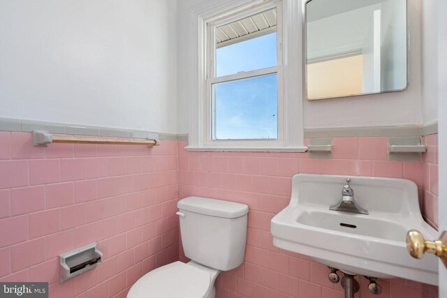 bathroom featuring a sink, a wainscoted wall, and toilet