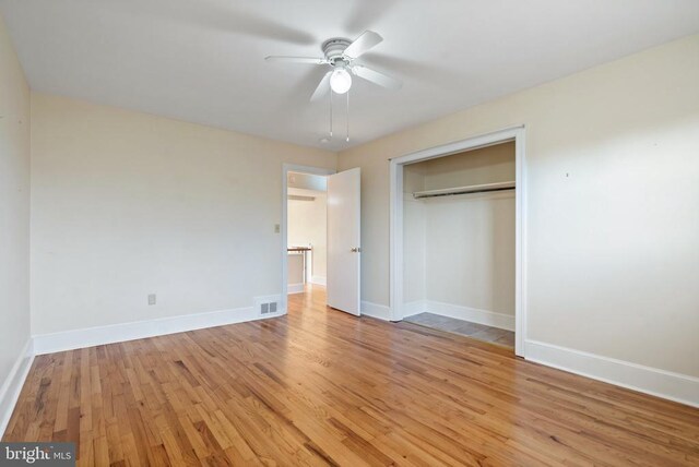 unfurnished bedroom featuring light wood-type flooring, visible vents, a ceiling fan, a closet, and baseboards