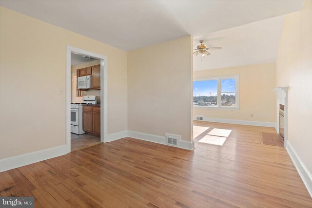 unfurnished living room featuring visible vents, a fireplace, baseboards, and light wood-style floors