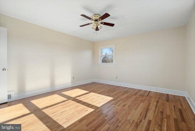 spare room with wood finished floors, baseboards, and ceiling fan