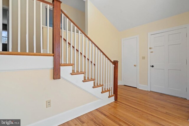 entryway with stairway, baseboards, and wood finished floors