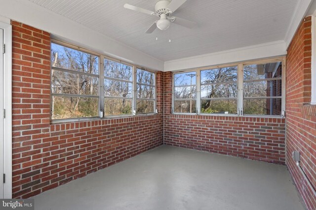 unfurnished sunroom featuring a ceiling fan