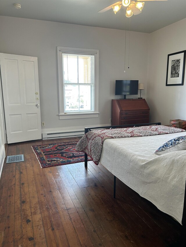 bedroom featuring ceiling fan, visible vents, hardwood / wood-style floors, and a baseboard radiator