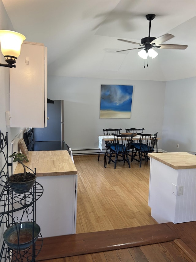 kitchen featuring white cabinets, ceiling fan, light wood-style floors, butcher block countertops, and freestanding refrigerator