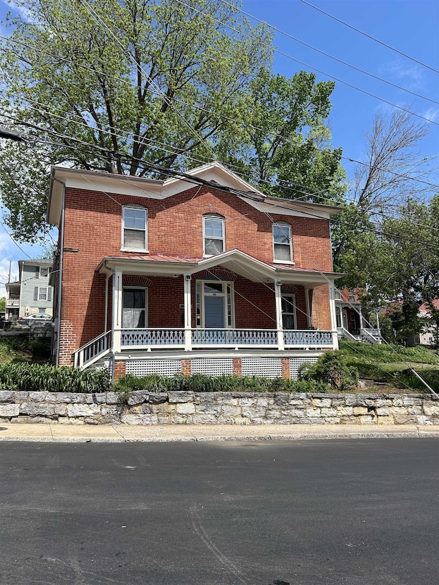 view of front facade with a porch and brick siding
