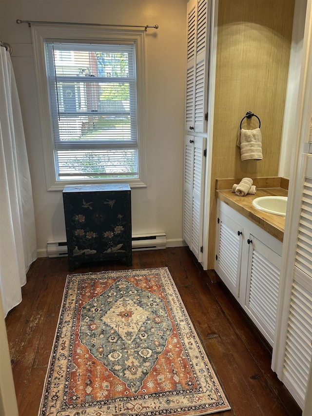 full bathroom featuring vanity, baseboard heating, and hardwood / wood-style floors