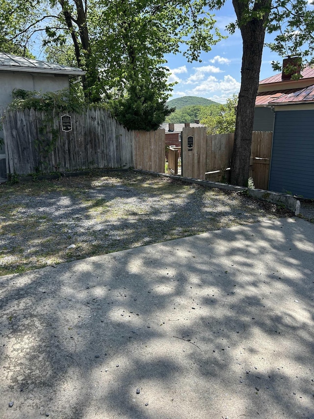 view of yard featuring fence, a mountain view, and a gate