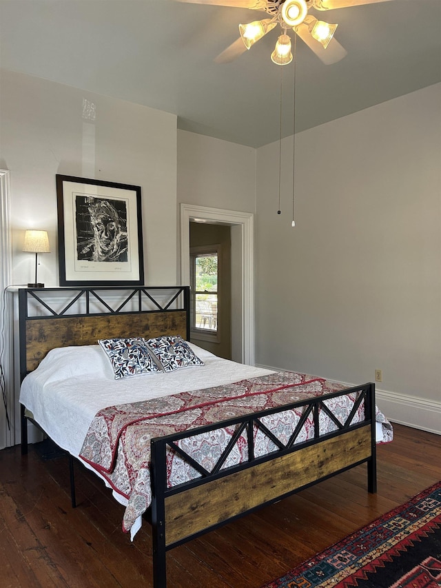 bedroom with wood-type flooring, a ceiling fan, and baseboards
