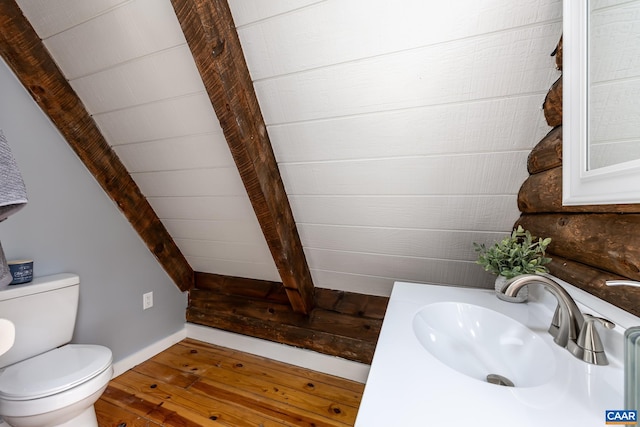 bathroom with vanity, hardwood / wood-style floors, beam ceiling, and toilet