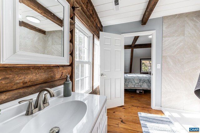 bathroom with vanity, lofted ceiling with beams, and hardwood / wood-style floors