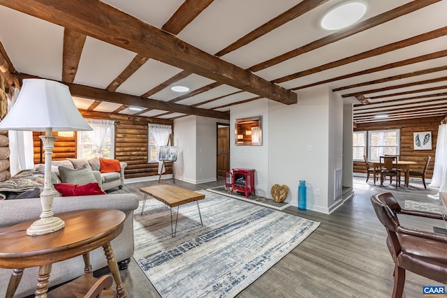 living room with beamed ceiling, dark hardwood / wood-style floors, and rustic walls